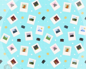 Könnte beinhalten: Ein sich wiederholendes Muster auf hellblauem Hintergrund mit Bildern im Polaroid-Stil, die Katzen, Landschaften und Nachtszenen zeigen. Kleine schwarze Kameras und gelbe Sternausbrüche sind über das Design verstreut.