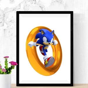 May include: Framed print featuring Sonic the Hedgehog in a dynamic pose, running through a golden ring. The artwork showcases the character's blue fur, red shoes, and white gloves against a white background, framed in black.