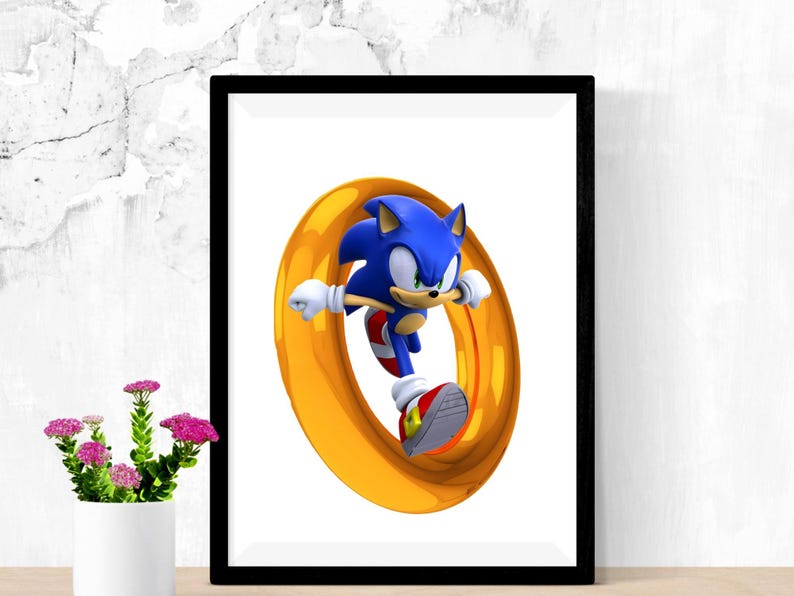 May include: Framed print featuring Sonic the Hedgehog in a dynamic pose, running through a golden ring. The artwork showcases the character's blue fur, red shoes, and white gloves against a white background, framed in black.