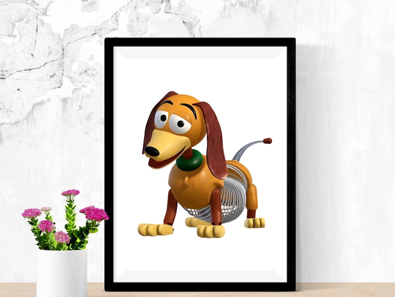 May include: Framed print featuring a cartoon dachshund toy. The dog has a yellow body, brown ears, and a green collar. Its midsection is a silver spring. The artwork is set against a white background, framed in black.