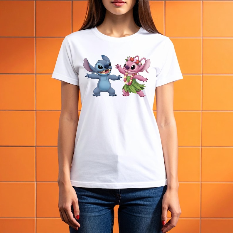May include: White t-shirt with a cartoon image of Stitch and Angel. Stitch is blue, Angel is pink, both with arms outstretched. Angel wears a flower crown and grass skirt. The t-shirt has a classic crew neck.