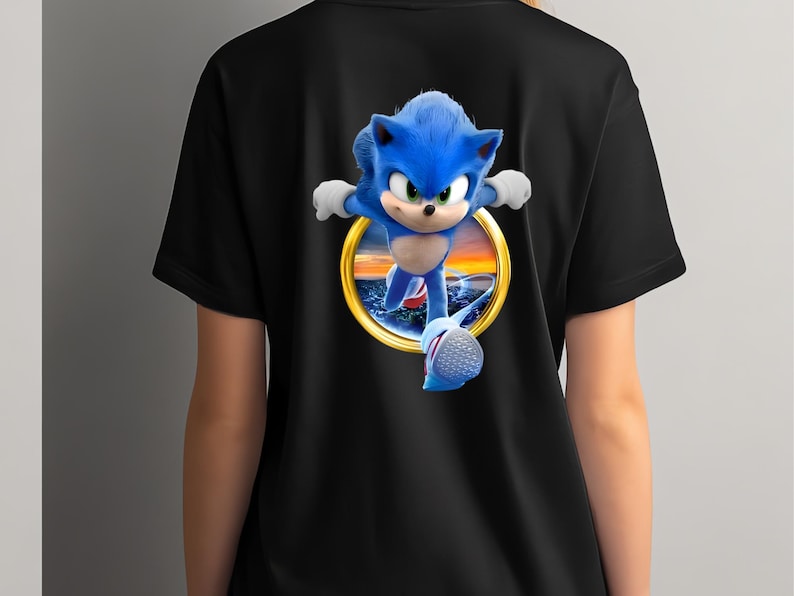 May include: Black t-shirt featuring a vibrant graphic of Sonic the Hedgehog in a running pose. The character is depicted in blue with white gloves and shoes, set against a sunset scene within a golden ring. A fun, eye-catching design for fans.