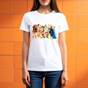 May include: White crew neck t-shirt with a vibrant graphic of animated princesses. The design showcases characters in their iconic attire. The shirt is crafted from a soft, lightweight fabric.