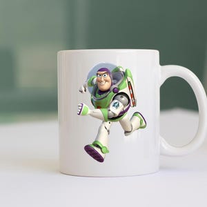 May include: White ceramic mug featuring a full-color image of Buzz Lightyear from Toy Story. The character is depicted in his signature green, white, and purple spacesuit, mid-stride. The mug has a curved handle.