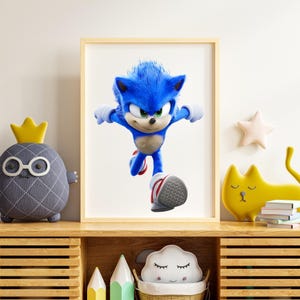 May include: A framed print featuring Sonic the Hedgehog in a dynamic running pose. The character is rendered in vibrant blue with white gloves and red and white sneakers. The artwork is displayed on a wooden shelf with decorative items.