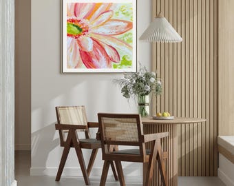 May include: A framed abstract floral painting with a close-up view of a flower in shades of pink, orange, and green. The painting hangs above two wooden chairs with woven cane backs and a round wooden table.