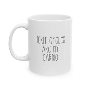 May include: A white ceramic coffee mug with a curved handle. The mug features the text "MERIT CYCLES ARE MY CARDIO" in black, handwritten-style lettering. The mug is designed for hot beverages.
