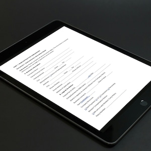 May include: A black tablet displaying a white document with text. The document appears to be a form with various fields for filling out information. The tablet is on a dark surface.