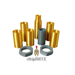 Könnte beinhalten: Eine Ansammlung goldfarbener zylindrischer Objekte und grauer Sechskantmuttern. Die Objekte variieren in Größe und Form, einige ähneln Patronenhülsen. Das Bild enthält auch ein graues zylindrisches Objekt und den Text "erfolgsDRUCK".