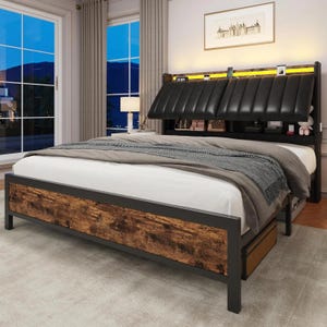 May include: A modern bed frame with a black metal frame and a headboard with a black leather padded design. The footboard has a rustic wood panel. The bed is made up with white sheets and a gray blanket.