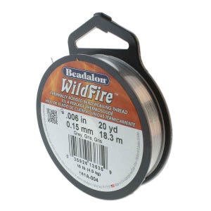 May include: A spool of Beadalon WildFire thermally bonded bead weaving thread in grey. The label specifies a diameter of .006 inches, a length of 20 yards, and a 10 pound test strength. The spool features a black plastic hanger and a barcode.