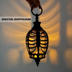 May include: A black lantern with a cage structure resembling a human ribcage, featuring a circular hanging ring at the top. The lantern emits a warm, glowing light from within, casting soft shadows. The text DIGITAL DOWNLOAD is visible.