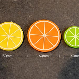 May include: A set of three ceramic mugs with a speckled, matte finish. The mugs are in shades of cream, light gray, and dark gray. Each mug has a simple, minimalist design and a rounded handle. The mugs are likely for coffee or tea.