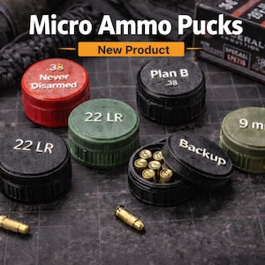 May include: Micro Ammo Pucks are shown in this image. There are several small, round containers in various colors, including red, green, and black. Each container is labeled with text such as "22 LR" and "9 mm." Some containers are open, revealing small bullets.