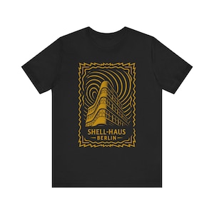 Peut inclure: T-shirt noir avec une illustration dorée du bâtiment Shell-Haus à Berlin. Le design comprend la façade du bâtiment et le texte "SHELL-HAUS BERLIN" dans un cadre décoratif. Le t-shirt est fait d'une matière douce.