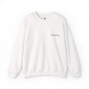 May include: Off-white crewneck sweatshirt with long sleeves. The sweatshirt features a small black graphic on the upper chest and the word "Prenzlauerberg" in black script on the right side. The garment is made of a soft, comfortable material.