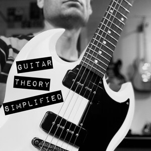May include: A monochrome image of a white electric guitar with black components. The guitar features the text "GUITAR THEORY SIMPLIFIED" and the name "MARK WADE". The guitar's design is clearly visible.
