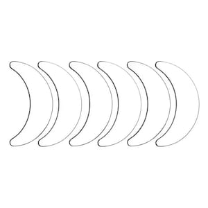 Puede incluir: Seis parches oculares blancos en forma de media luna dispuestos en fila. Cada parche tiene un fino contorno negro y están sobre un fondo blanco liso. Los parches son lisos y curvos.