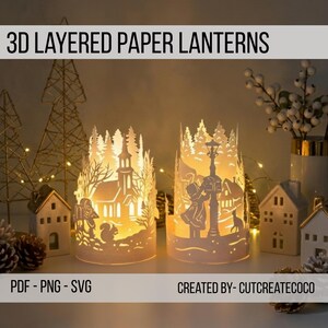 Könnte beinhalten: Zwei weiße 3D-Papierlaternen mit aufwendigen Ausschnitten einer Kirche und eines Paares unter einer Straßenlaterne. Die Laternen sind von innen beleuchtet und erzeugen ein warmes Leuchten. Der Text "3D LAYERED PAPER LANTERNS" steht oben.