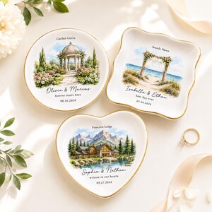 May include: Three white ceramic trinket dishes with gold rims. One round dish features a garden gazebo, one square dish shows a beach arch, and one heart-shaped dish depicts a mountain lodge. Each includes custom names, dates, and location text.