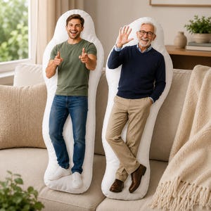 May include: Two large, white, human-shaped body pillows featuring high-resolution photographic prints of two different individuals. One pillow displays a younger person in a green t-shirt and blue jeans, while the other shows an older person in a navy sweater.