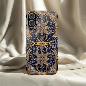 Può includere: Una custodia per smartphone con un design ornato e dettagliato. La custodia presenta uno sfondo blu scuro con motivi floreali e geometrici dorati e azzurri. Il design include accenti simili a gioielli.