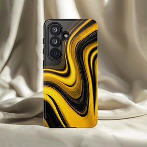 May include: A black smartphone case with a swirling yellow and black abstract design. The case has a camera module with three lenses on the upper left side. The background is a neutral, off-white fabric.