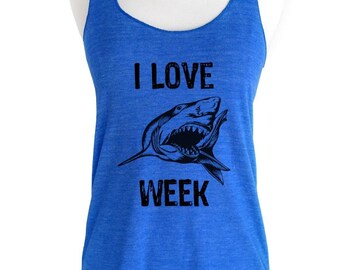 May include: A royal blue tank top with a black graphic of a shark with the text "I LOVE WEEK" printed on it.