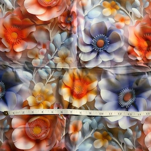 Könnte beinhalten: Ein Stoff mit floralem Muster, das große, stilisierte Blumen in Orange-, Pfirsich-, Gelb- und Lilatönen zeigt. Die Blumen haben detaillierte Zentren und sind mit kleineren Blüten und hellblauen Blättern durchsetzt. Ein Maßband liegt auf dem Stoff.