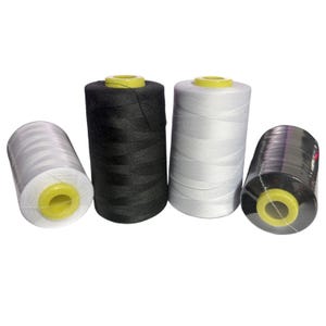 May include: Four spools of thread in black, white, and gray. The spools have yellow centers and are tightly wound. One spool is wrapped in clear plastic. The threads are likely for sewing or crafting projects.
