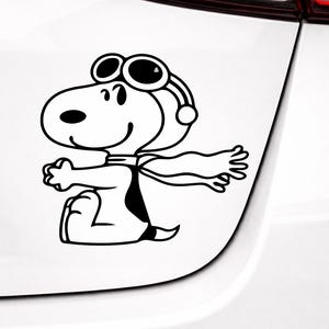 Puede incluir: Calcomanía de vinilo en blanco y negro de Snoopy, el perro, con gafas y bufanda, con los brazos extendidos. El personaje de dibujos animados está sentado, con una expresión feliz. La calcomanía está diseñada para ser aplicada a un coche u otra superficie lisa.