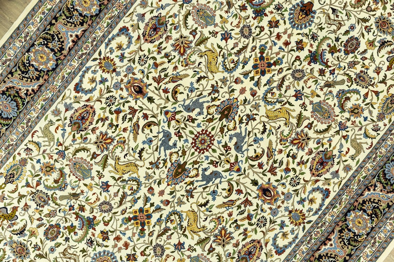 May include: Ivory-colored Persian rug with an intricate floral pattern. The design features a central field with detailed flowers, leaves, and animal figures in shades of blue, brown, and green. A dark border frames the rug.