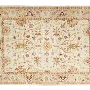 .Oversized vintage Turkish Oushak rug with a creamy ivory field, muted blush and golden ochre botanical motifs, and wide traditional floral borders.