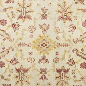 May include: A cream-colored rug with a floral pattern in shades of brown, pink, and yellow. The rug has a traditional Persian design with intricate details.