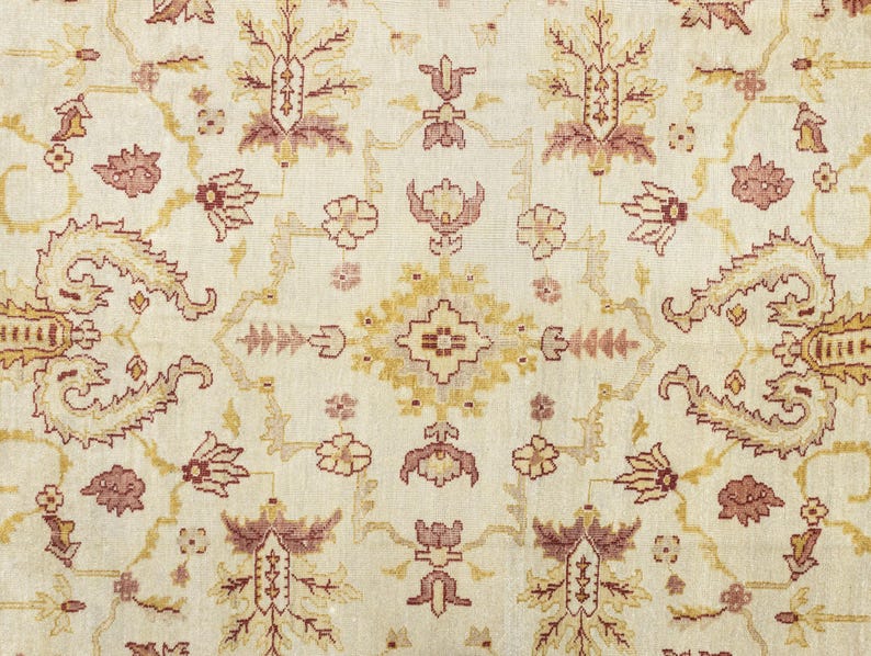 May include: A cream-colored rug with a floral pattern in shades of brown, pink, and yellow. The rug has a traditional Persian design with intricate details.