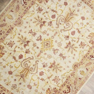 Vintage Turkish Oushak oversize rug 9.8x13.2 ft with creamy ivory base, blush gold tones, styled in elegant traditional living room