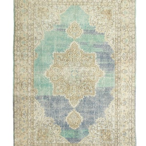 May include: A rectangular, distressed-look rug with a central medallion design. The rug features a color palette of light blue, beige, and gray. The border has an ornate pattern, and the rug has a faded, vintage appearance.