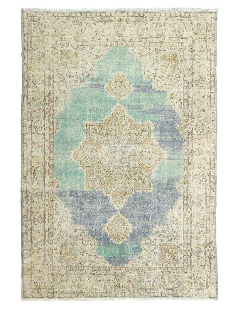 May include: A rectangular, distressed-look rug with a central medallion design. The rug features a color palette of light blue, beige, and gray. The border has an ornate pattern, and the rug has a faded, vintage appearance.