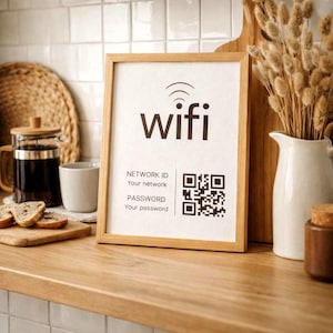 May include: A framed sign with the word "wifi" in black, along with a network ID and password section. The sign is in a light wood frame and sits on a wooden surface. A QR code is included for easy access.