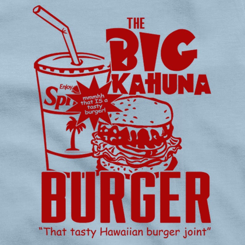 K&ouml;nnte beinhalten: Hellblaues T-Shirt mit rotem Aufdruck. Das Design zeigt einen Burger, ein Soda-Glas und den Text "The Big Kahuna Burger" und "That tasty Hawaiian burger joint."