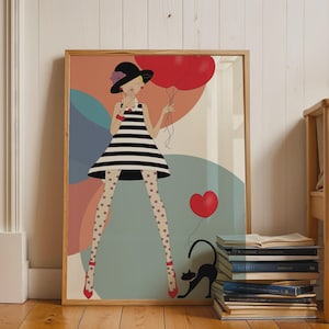 Peut inclure: Une impression d'art encadrée représentant une illustration stylisée d'une personne portant une robe à rayures noires et blanches, un chapeau noir avec une fleur violette et des collants à pois. Elle tient des ballons rouges et un chat noir.