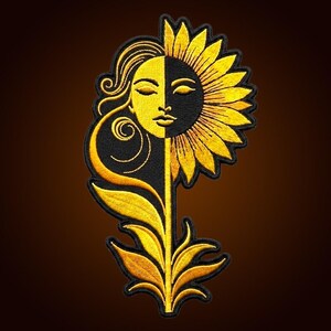 Puede incluir: Un parche bordado que presenta un diseño dividido entre un rostro y un girasol. El lado izquierdo es dorado con un perfil humano, mientras que el derecho es negro con pétalos de girasol. El tallo y las hojas en la parte inferior son dorados.