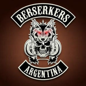 May include: A black and white embroidered patch featuring a central graphic of a wolf head wearing a helmet above a skull with curved tusks. The text BERSERKERS is arched above the graphic, and the text ARGENTINA is arched below the graphic.