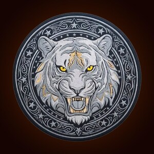 May include: A circular embroidered patch featuring a snarling white tiger head with piercing yellow eyes. The tiger is framed by a dark border decorated with silver stars and intricate knotwork patterns, creating a detailed, high-contrast design.