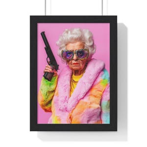 Puede incluir: Impresión artística enmarcada que presenta a una persona mayor con cabello blanco, usando gafas de sol grandes y enjoyadas y un abrigo de piel sintética colorido. La persona sostiene una pistola negra sobre un fondo rosa.