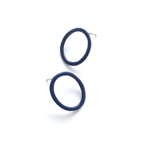 May include: A pair of blue circle stud earrings. The earrings are made of metal and have a simple, modern design.