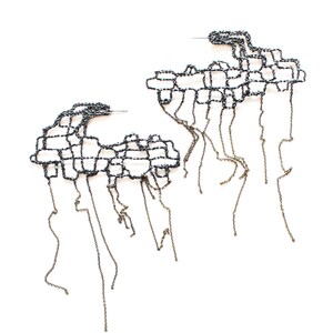 May include: A pair of black metal earrings with a geometric design and dangling chains.