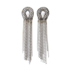 May include: A pair of silver dangle earrings with a beaded circle at the top and long chains of silver beads hanging down.