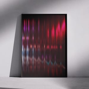 May include: Abstract art print in a black frame. The artwork features vertical streaks of red, pink, purple, and blue hues against a dark background. The framed art is leaning against a white wall, with shadows cast across a concrete floor.