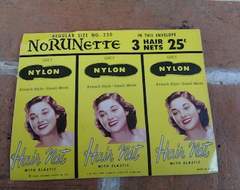 May include: A vintage package of three grey nylon hair nets with elastic. The package is labeled "Norunnette" and says "Regular Size No. 230" and "In this envelope 3 hair nets 25 cents".